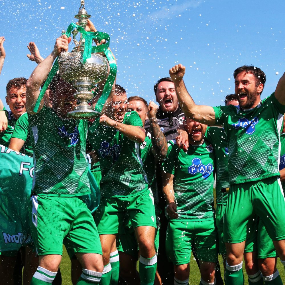 Winning football team holding up trophy